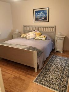 a bedroom with a bed with two pillows and a rug at Eymet Townhouse in Eymet