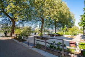 un parc avec des arbres, une clôture et un banc dans l'établissement Studio cosy sur l’île de Nantes / Proche Tramway, à Nantes