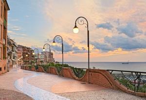 a row of street lights on a sidewalk near the ocean at APPARTAMENTO CORSO VITTORIO EMANUELE in Ortona