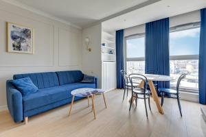 uma sala de estar com um sofá azul e uma mesa em Grano Residence Comfort Apartments em Gdansk