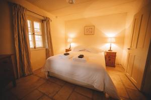 1 dormitorio con cama blanca y ventana en Goat Square Cottages, en Tanunda