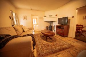 a living room with a couch and a tv at Goat Square Cottages in Tanunda