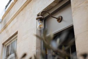 a light on the side of a building at The Yard in Bath Hotel in Bath