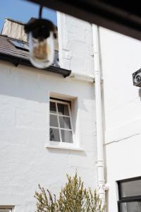 a cat sitting in a window of a white house at The Yard in Bath Hotel in Bath