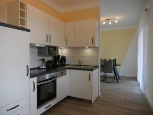 a kitchen with white cabinets and a stove top oven at Seeoase Lychen in Lychen