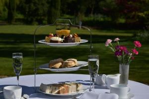 a table with two plates of food and glasses of wine at Guyers House Hotel and Restaurant in Corsham