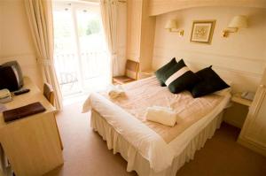 a bedroom with a large bed with a window at Old Court Hotel & Apartments in Symonds Yat