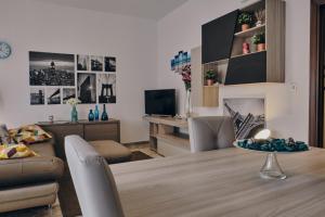 a living room with a dining room table and a living room with a couch at Asariel Splendido appartamento vista mare e centro storico in Brindisi