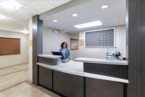 una mujer parada en una recepción en el vestíbulo de un hospital en Candlewood Suites Hattiesburg, an IHG Hotel, en Hattiesburg