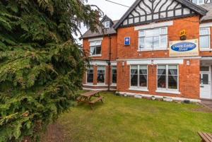 um edifício com uma mesa de piquenique em frente em The Quorn Lodge Hotel em Melton Mowbray