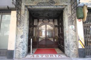 トリノにあるGreen Class Hotel Astoriaの大きな木製のドアのある建物の入口
