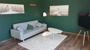 a living room with a couch and a tv at Timeout Lodges - Luxus für Zwei in Dudeldorf