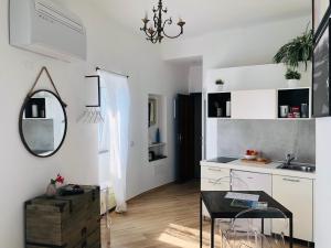 a white kitchen with a table and a mirror at La Bloo di Vernazza - Sea View - AC&WiFi - Vernazzarentals in Vernazza