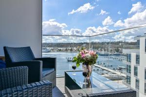 balkon ze szklanym stołem i kwiatami w obiekcie Apartament Faltom 20 Yacht Park Premium w mieście Gdynia