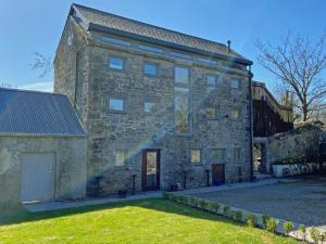 an old stone building with a grass yard at Kinvara Suites 2 in Kinvara