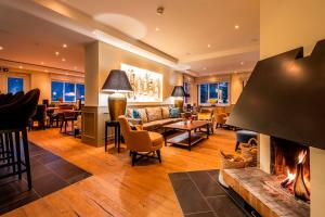 a living room with a fireplace and a couch at Hotel Birke, Ringhotel Kiel in Kiel