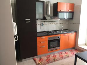 a kitchen with orange and black cabinets and a sink at APPARTAMENTO CORSO VITTORIO EMANUELE in Ortona