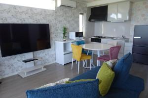 a living room with a blue couch and a table at Ocean Front SUMUIDE in Nago