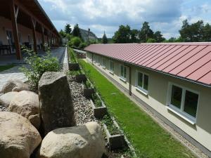 a building with a red roof and some rocks at Seeoase Lychen in Lychen