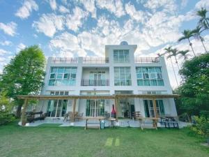 a large white house with a lawn in front of it at 朵麗絲森林 in Meishan