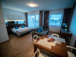 a hotel room with a bed and a table and a couch at ATRIUM Przystań w Sarbinowie in Sarbinowo