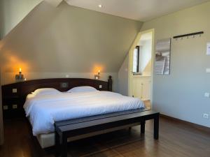 a bedroom with a large bed with a bench in it at Villa Hotel (Adults only) in Westende