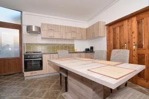 een keuken met een grote houten tafel en stoelen bij Apartment Werkstatt Castelului in Braşov