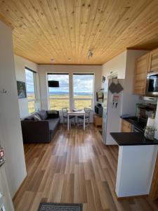 una cucina e un soggiorno con divano e tavolo di Blue View Cabin 3B With private hot tub a Reykholt