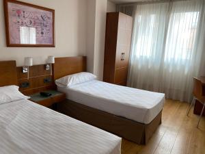 a hotel room with two beds and a window at Duerming Longoria Plaza Hotel in Oviedo
