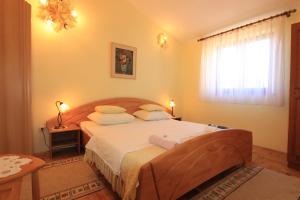 a bedroom with a large bed and a window at Apartments Gladiola Nin in Nin