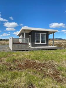 ein winziges Haus auf einem Feld in der Unterkunft Blue View Cabin 3B With private hot tub in Reykholt