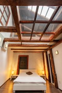 シビウにあるVendi Grand Square Residenceの木製の天井の客室で、ベッドルーム1室(ベッド1台付)