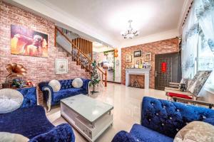 uma sala de estar com sofás azuis e uma parede de tijolos em Shanghai Time em Hualien City