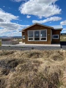 a house with a view of the ocean at Blue View Cabin 6A With private hot tub in Reykholt