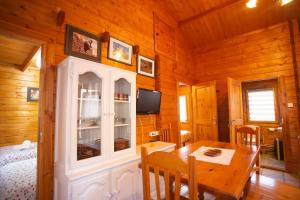 ein Esszimmer mit einem Tisch und einem TV in einer Hütte in der Unterkunft Bungalow Tossa Pelada i Mobil Home Rodell in Fornols