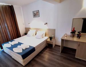 1 dormitorio con 1 cama con toallas en Hotel Largo Beach en Sunny Beach