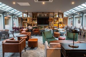 a lobby with couches and chairs and a tv at Lea Marston Hotel in Lea Marston