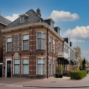 een rood bakstenen gebouw met een bord erop bij Stadslogement Hoogend in Sneek