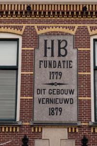 una señal en el lateral de un edificio de ladrillo en Stadslogement Hoogend, en Sneek
