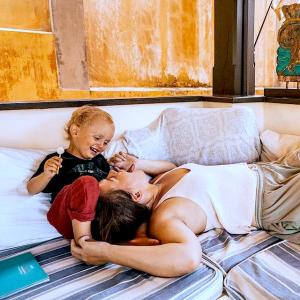 a woman and a child laying on a bed at Alanta Pool Villa in Ko Lanta