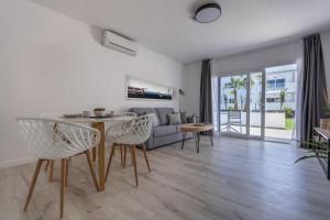 a living room with a table and chairs and a couch at Island Home Fuerteventura in Corralejo