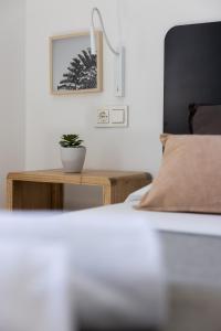a bedroom with a bed and a table with a plant on it at Island Home Fuerteventura in Corralejo