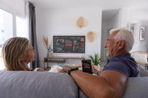 a man and a woman sitting on a couch at Island Home Fuerteventura in Corralejo