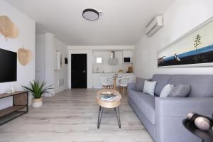 a living room with a blue couch and a table at Island Home Fuerteventura in Corralejo