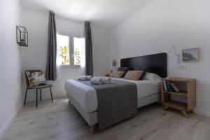 a bedroom with a large bed and a chair at Island Home Fuerteventura in Corralejo