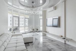 uma sala de estar com um sofá branco e um lustre em Royal Apartment em Odessa