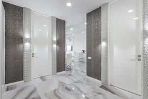 baño con suelo de mármol y cabina de ducha en Royal Apartment, en Odessa