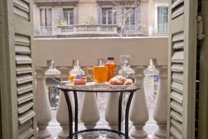 een tafel met een dienblad met eten op een balkon bij Barcelona City Centre Hostal in Barcelona