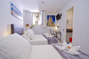 een witte slaapkamer met 2 bedden en een tafel bij Barcelona City Centre Hostal in Barcelona