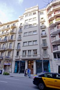 een groot wit gebouw waar mensen voor staan bij Barcelona City Centre Hostal in Barcelona